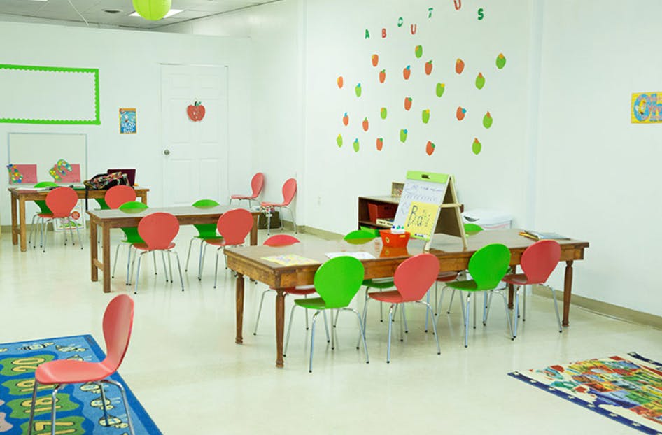 Empty classroom with small tables and colorful chairs