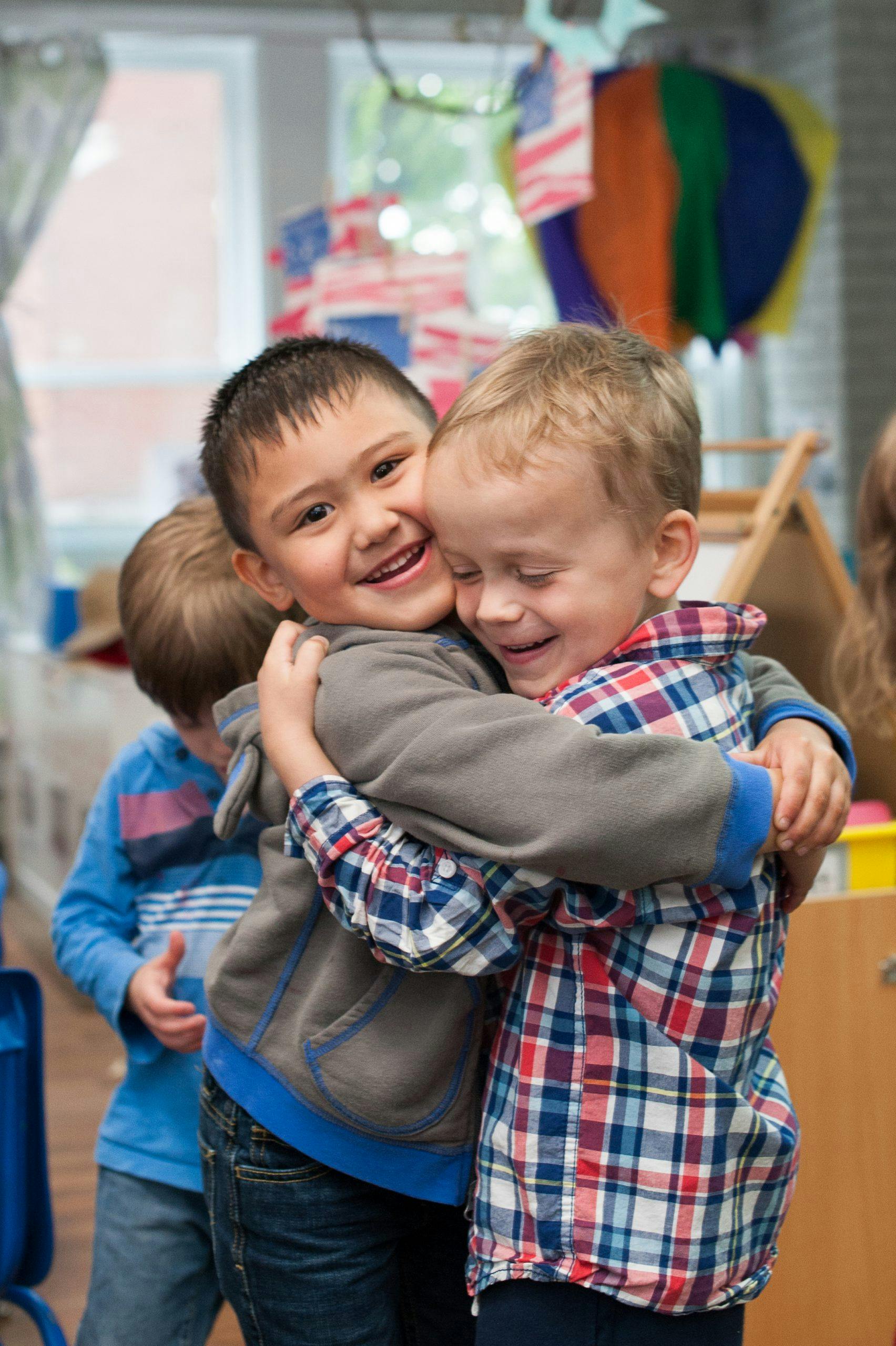 Two children hugging each other in a classroom