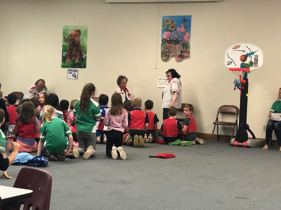 Adults and children sitting on the floor in a classroom