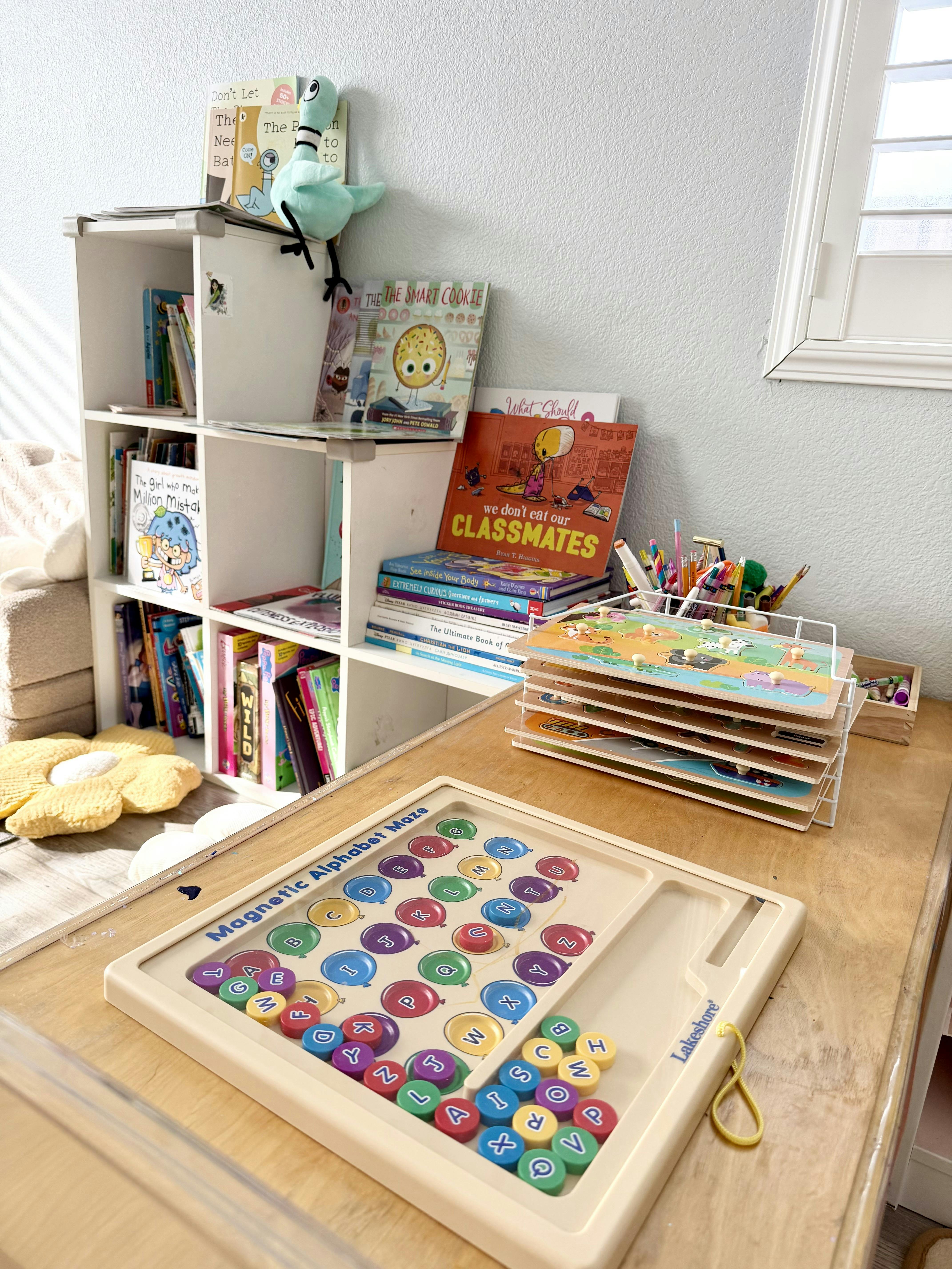 Classroom or playroom with a magnetic alphabet maze, puzzles, and a bookshelf with children's books