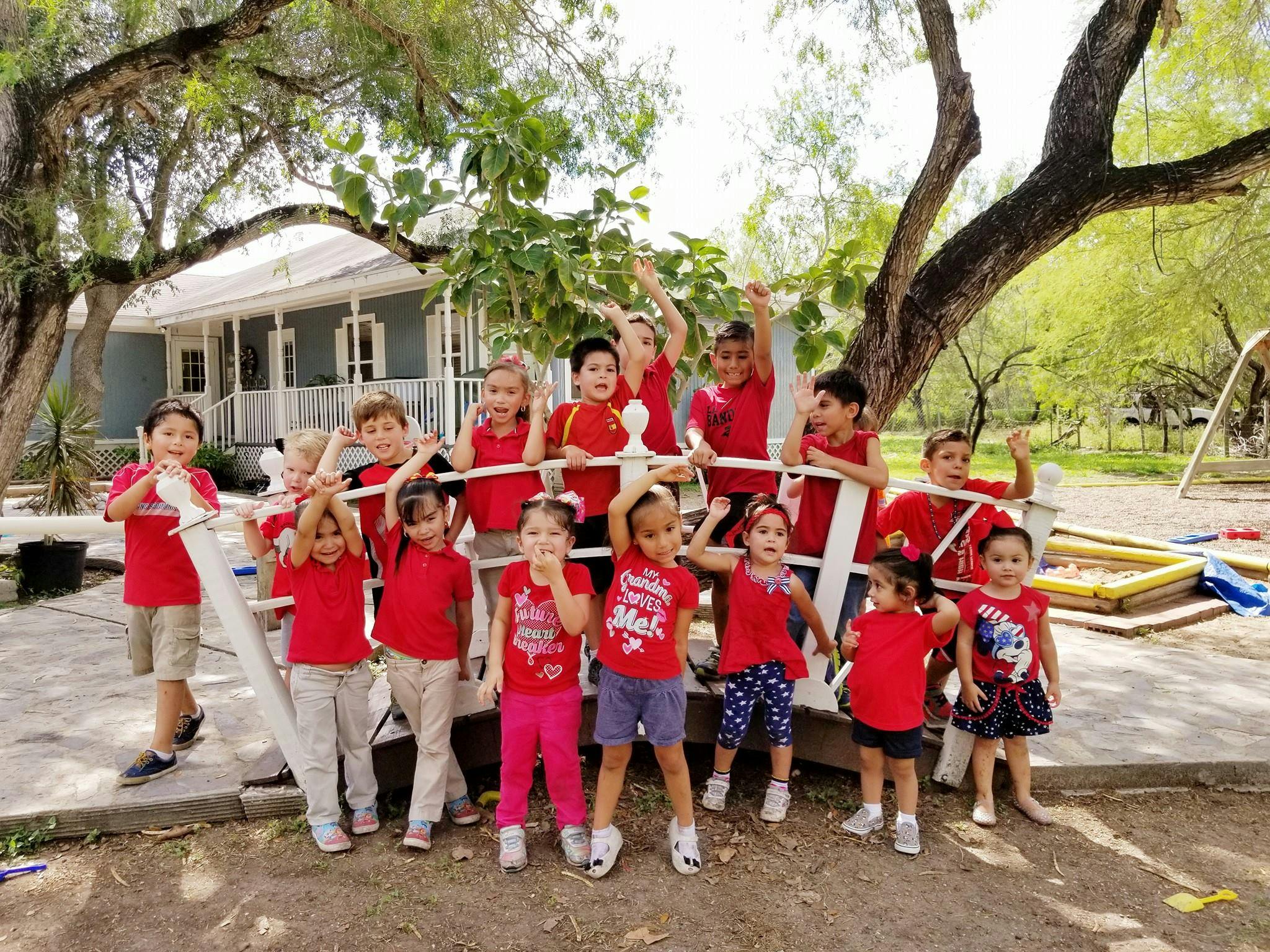 Group of children in red shirts posing outdoors