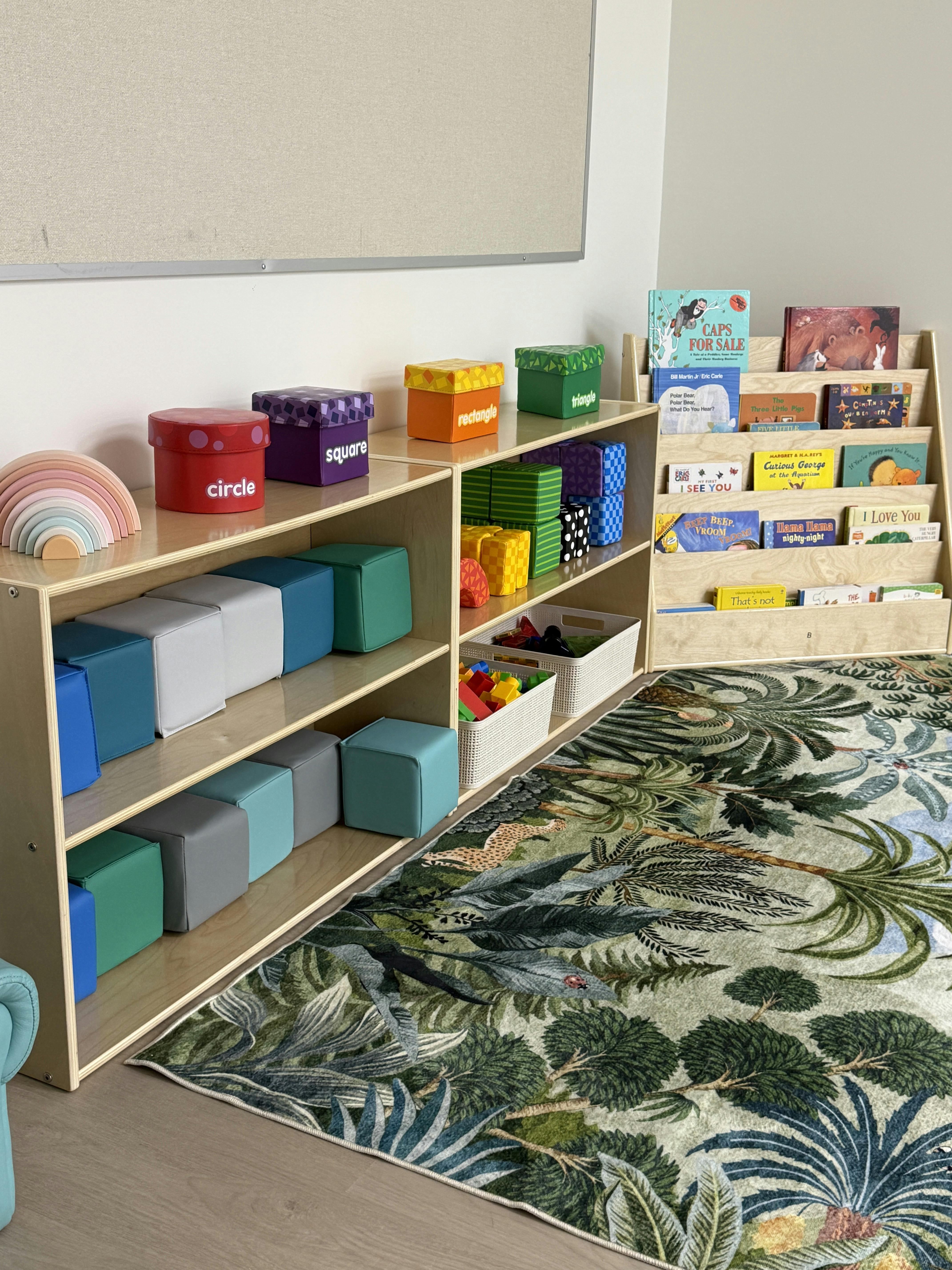 Classroom with shelves of colorful blocks, shape boxes, and children's books
