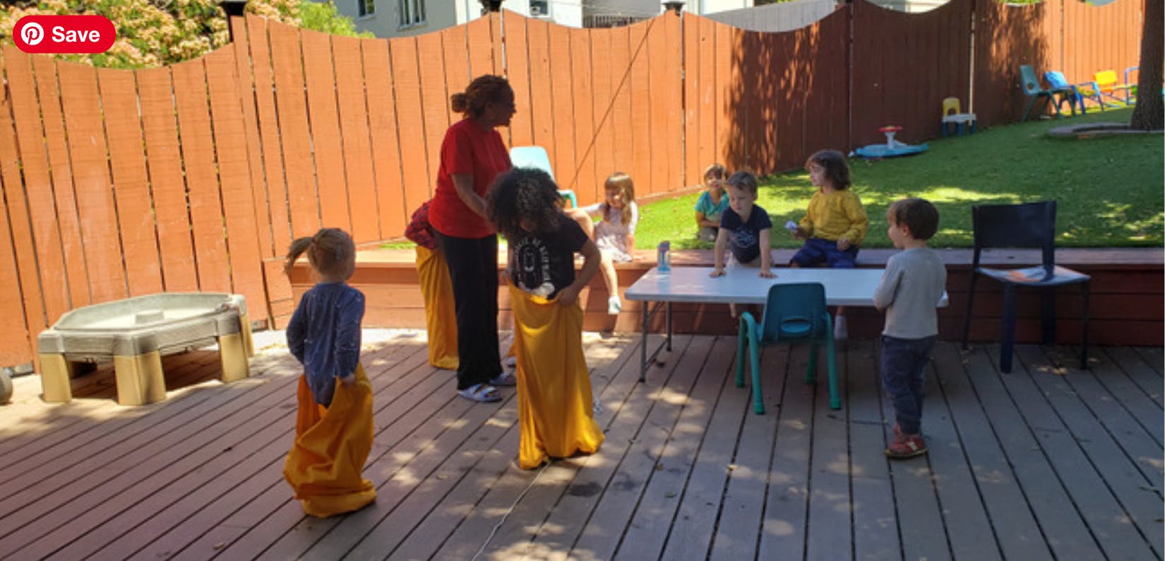 Adult and children playing a sack race on a wooden deck
