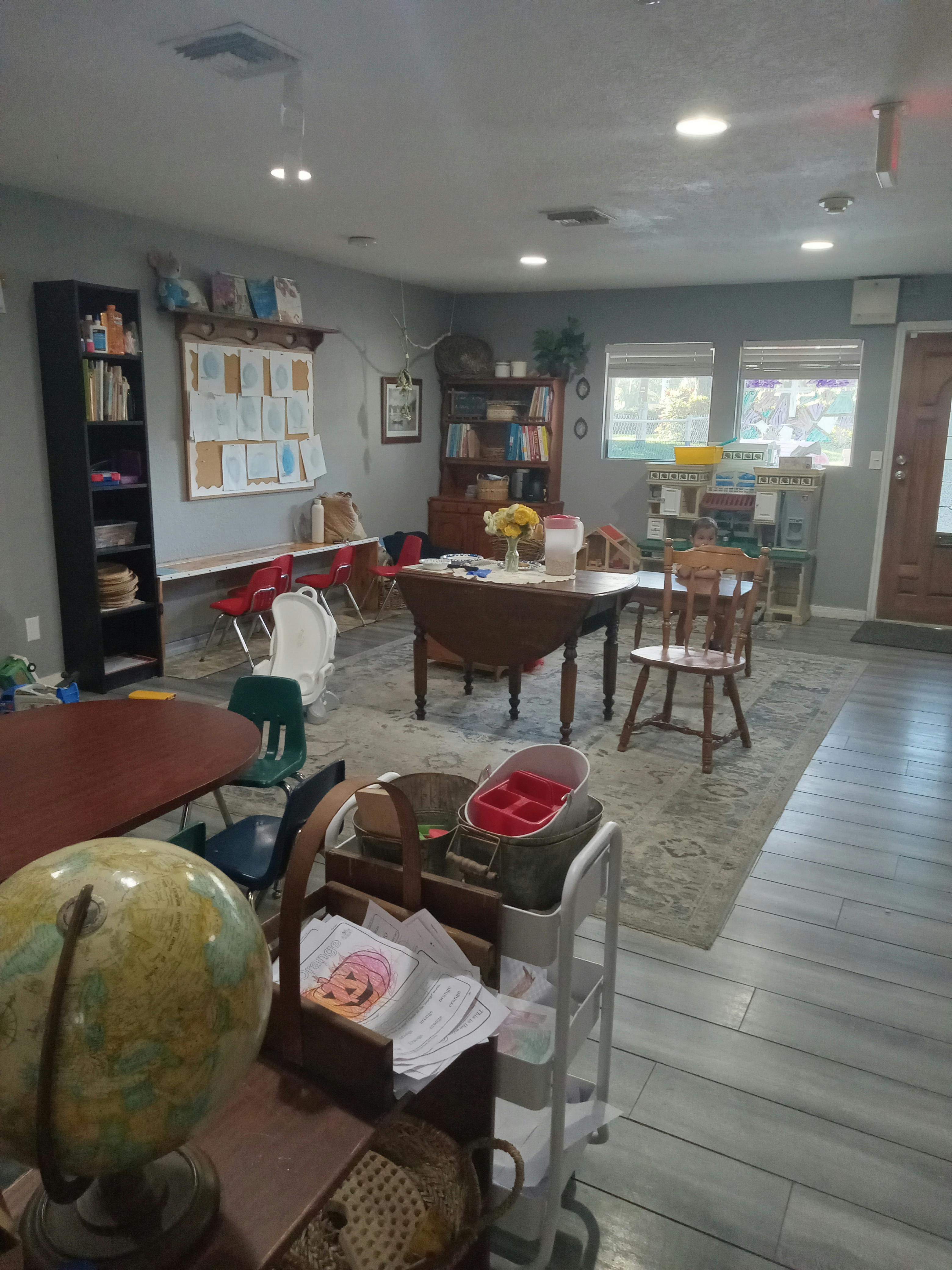 A room with multiple tables, chairs, and bookshelves