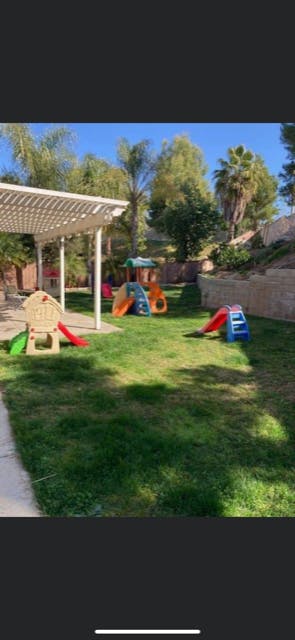 Playground with multiple slides and play structures on a grassy lawn
