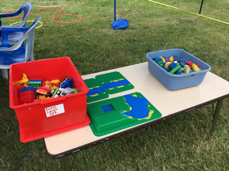 Table with bins of building blocks and green baseplates