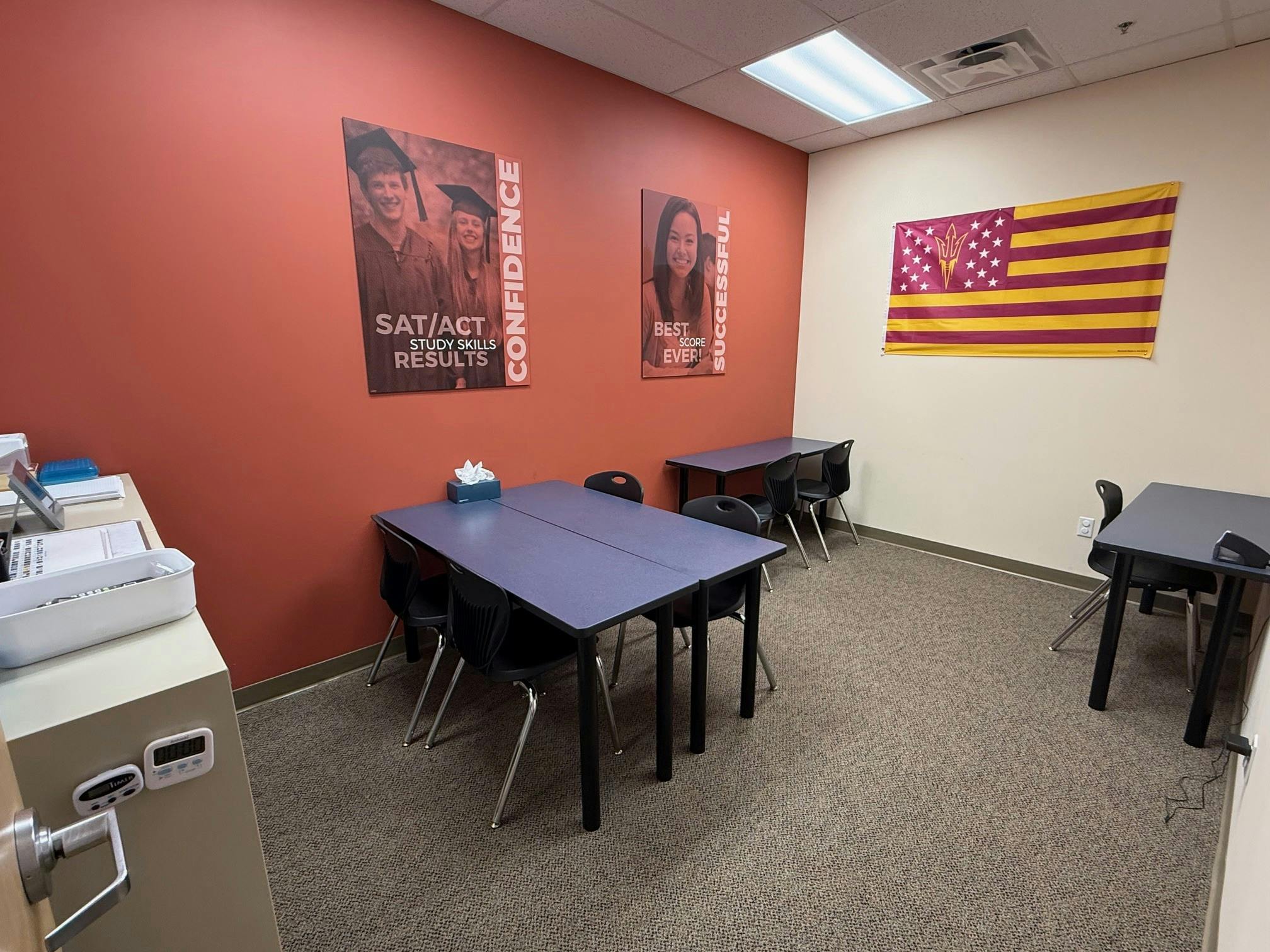 Classroom with tables, chairs, and posters on the wall