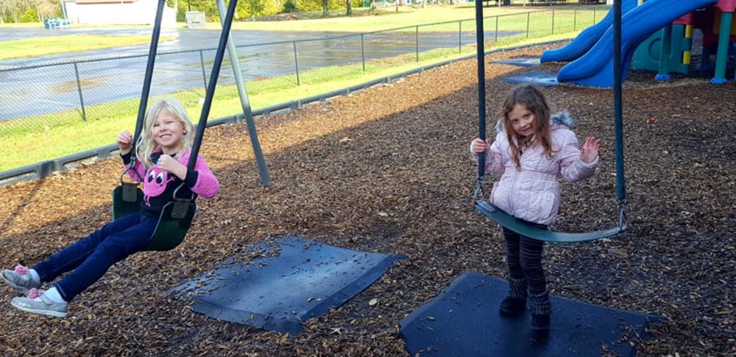 Two children on swings at a playground