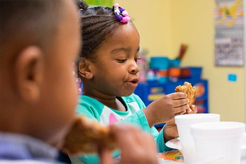 Child eating food at a table