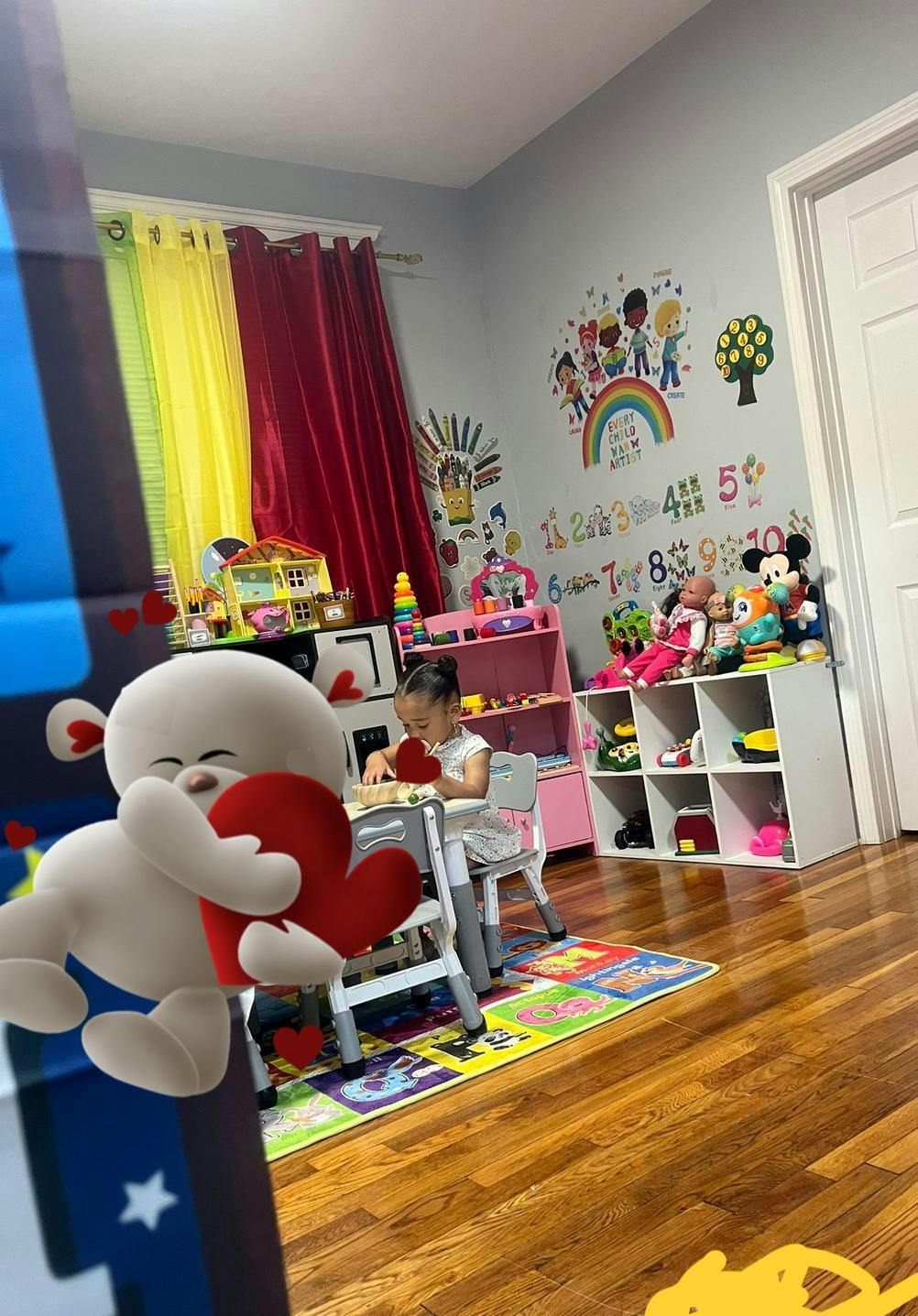 Child sitting at a small table, playing with toys