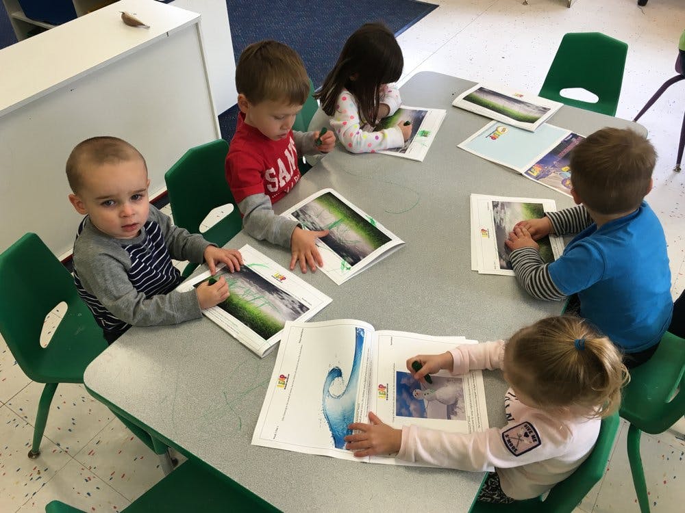 Children sitting at a table with books and papers