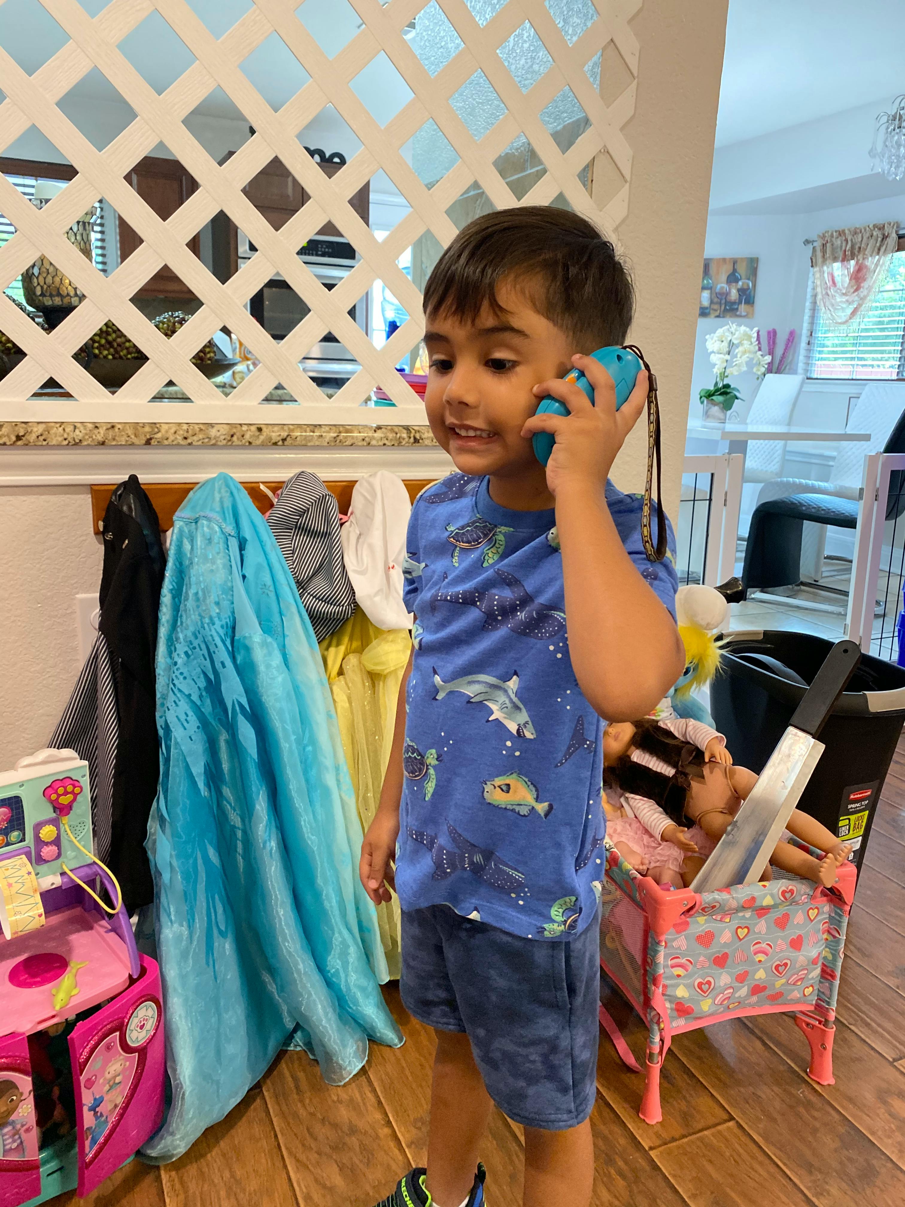 Child holding a blue toy phone to their ear