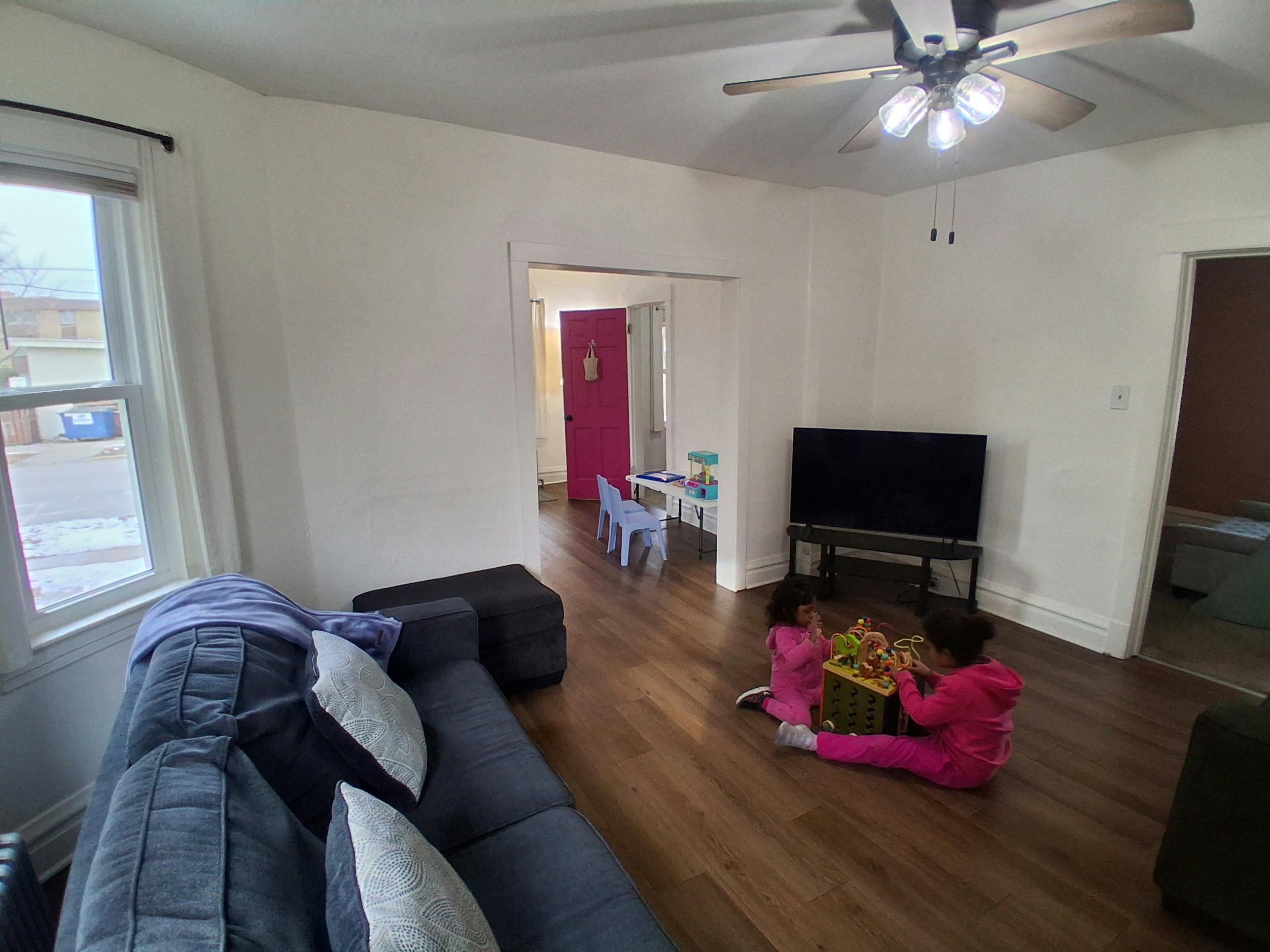 Two children playing with a toy on the floor in a living room