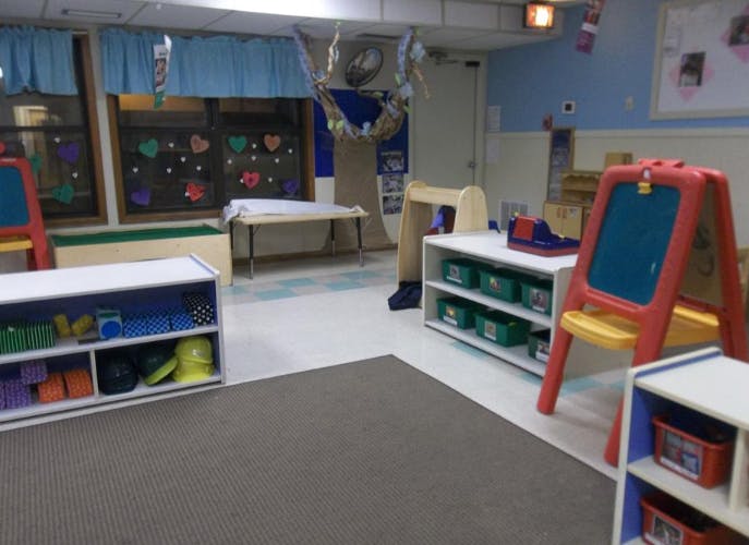 Empty colorful children's classroom with various shelves and easels