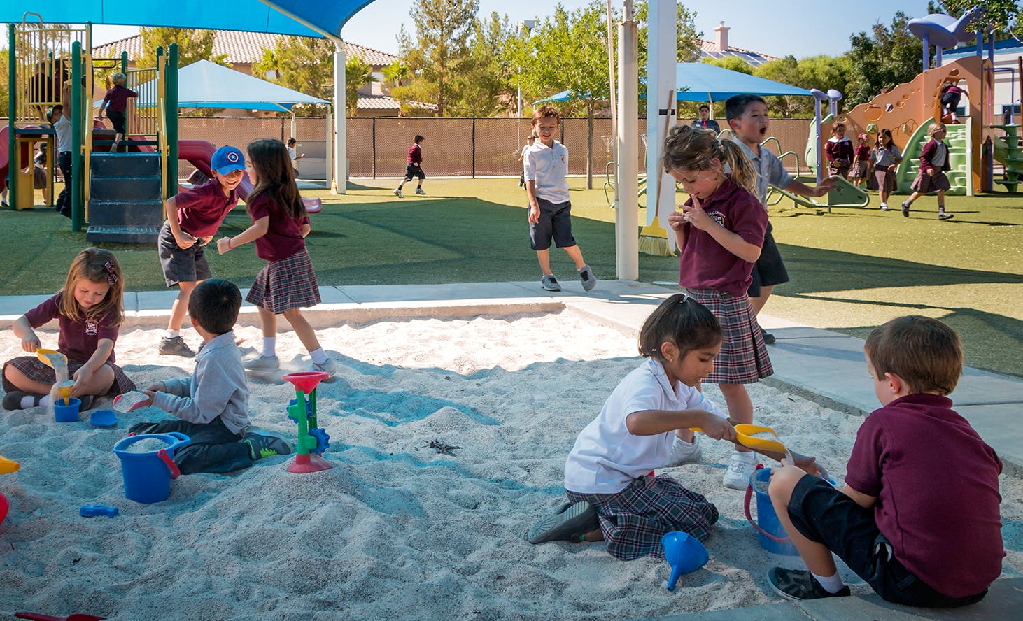 Children playing in a sandbox and on a playground