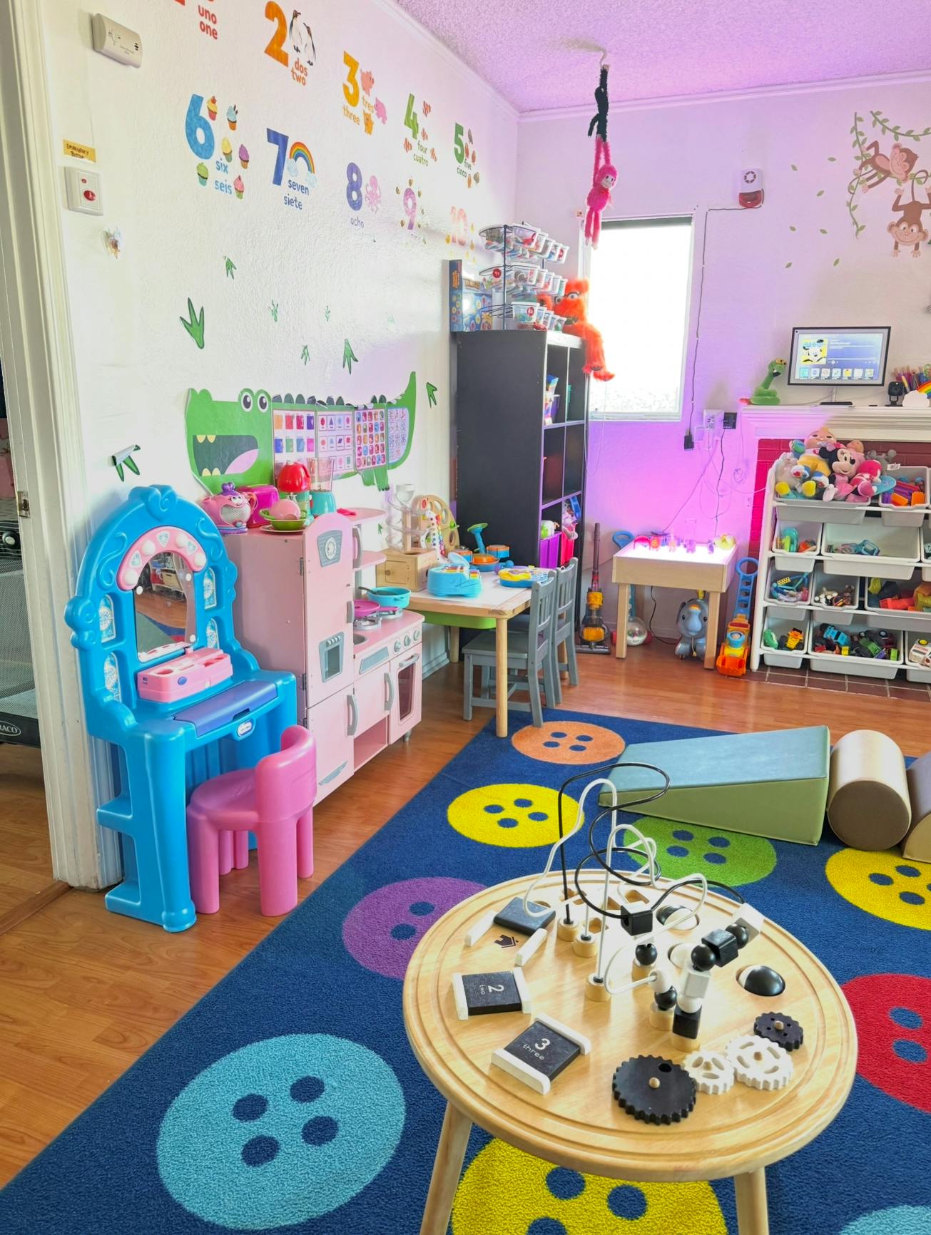 Playroom with a blue rug, toy kitchen, and various play items