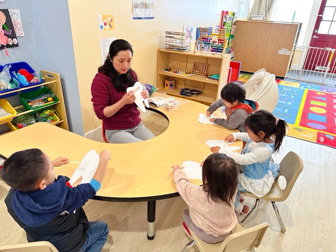 Person and children at a table in a classroom