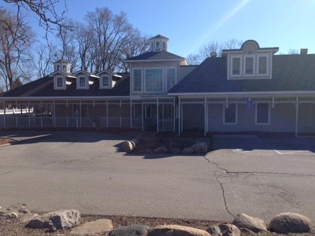 Single-story building with a wrap-around porch and cupolas