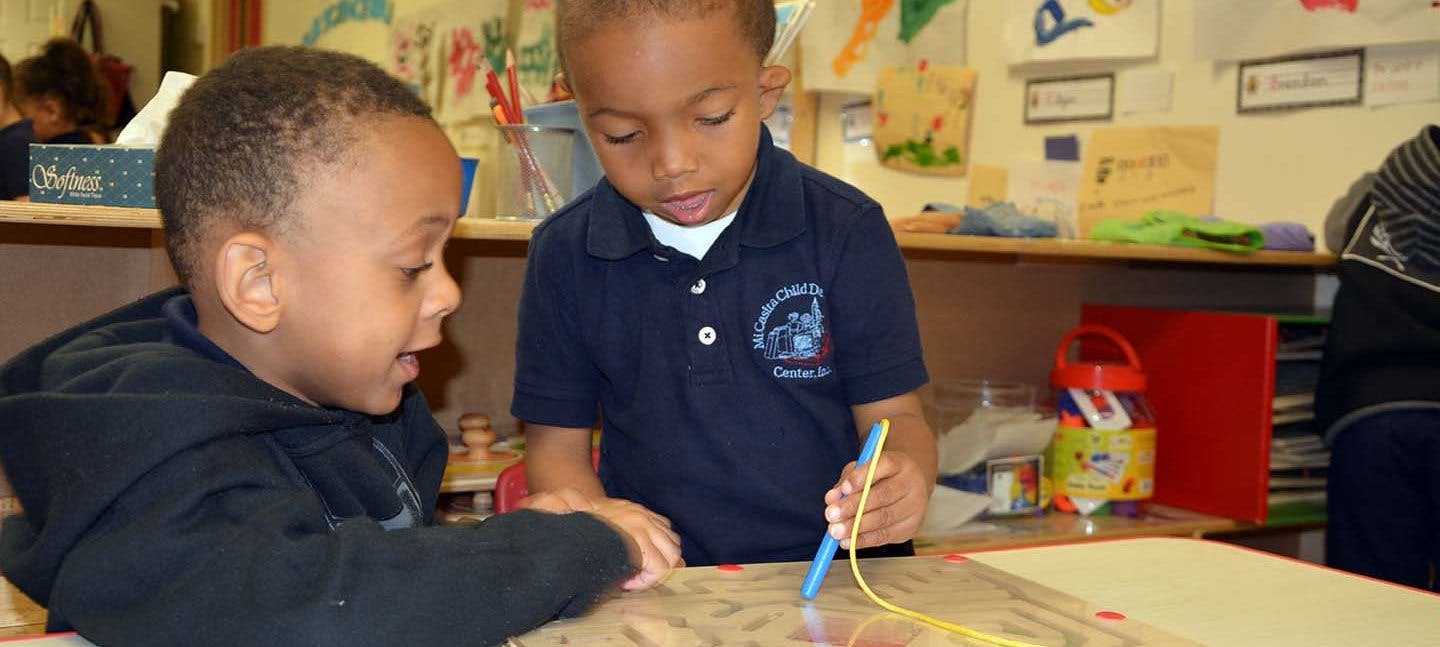 Two children drawing at a table