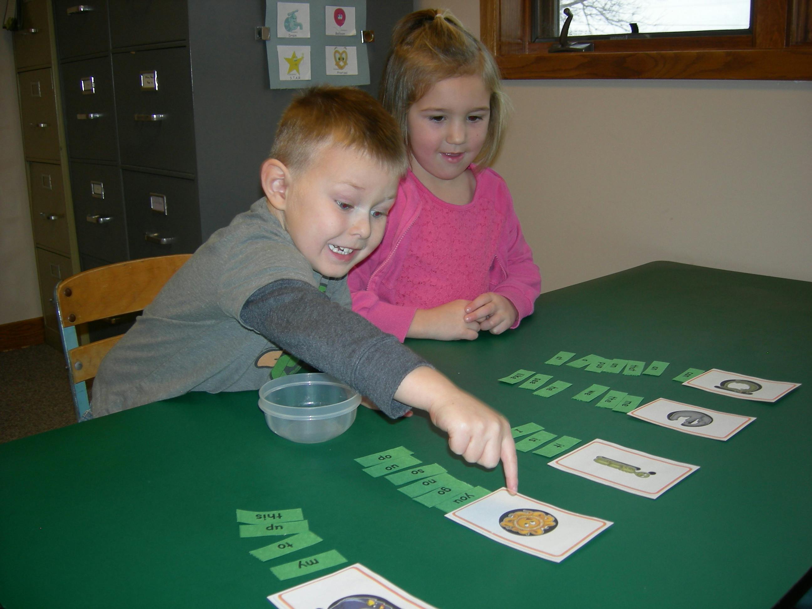 Two children playing a card game at a table