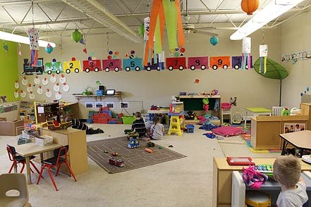 Children playing in a classroom with toys and decorations