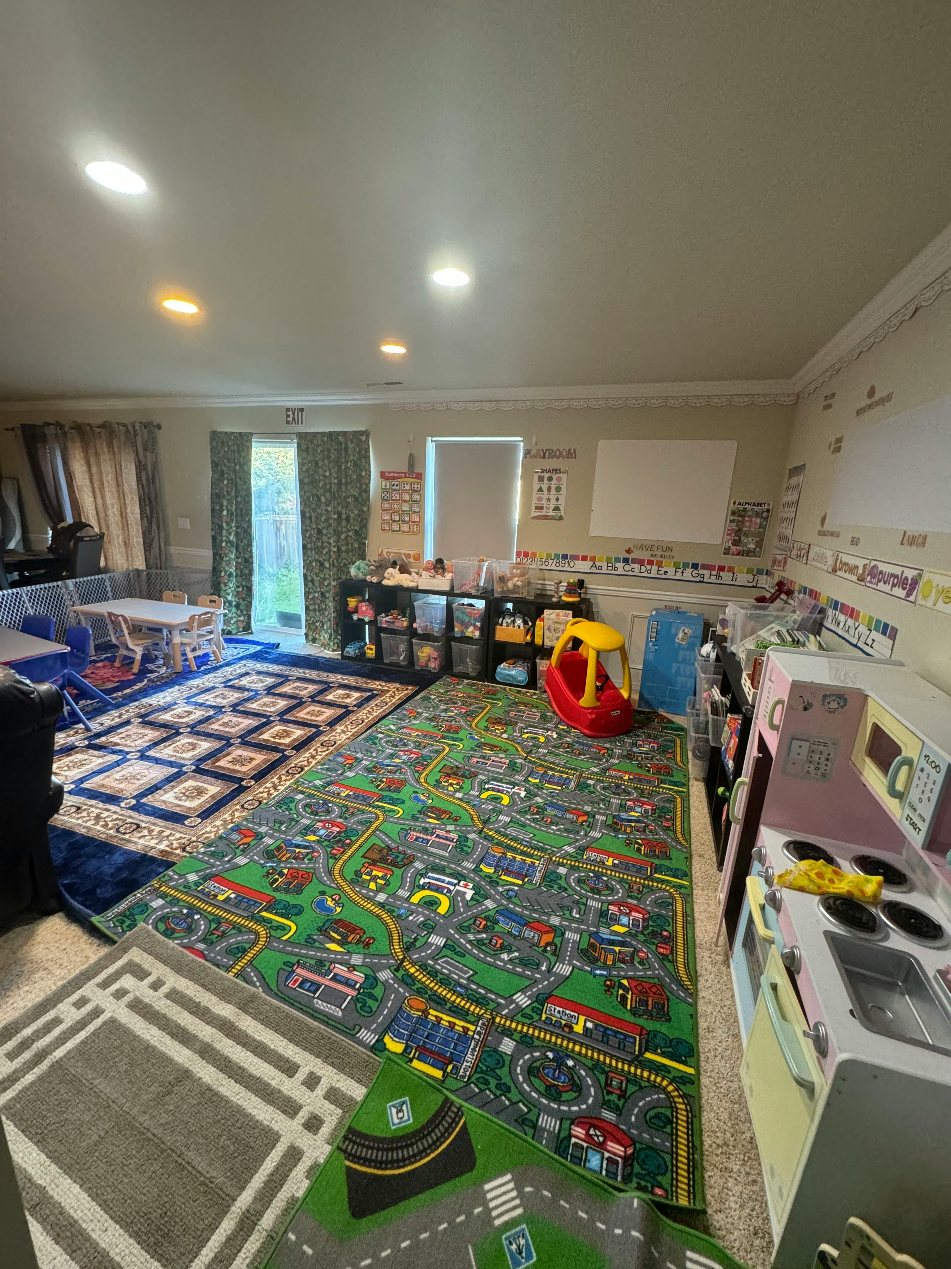 Playroom with a road map rug, a play kitchen, and a small table and chairs