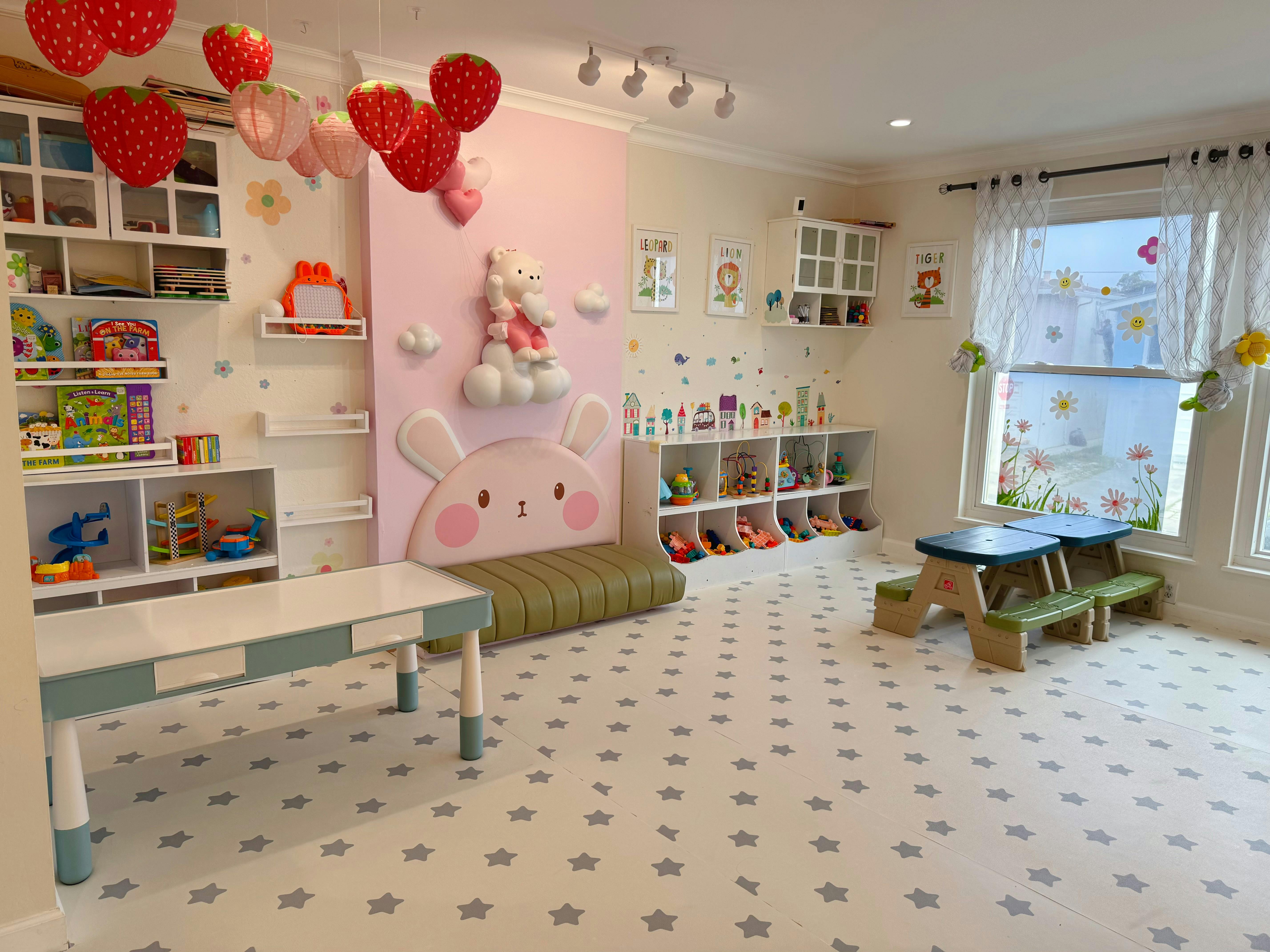 Playroom with tables, shelves of toys, and a window with a small picnic table