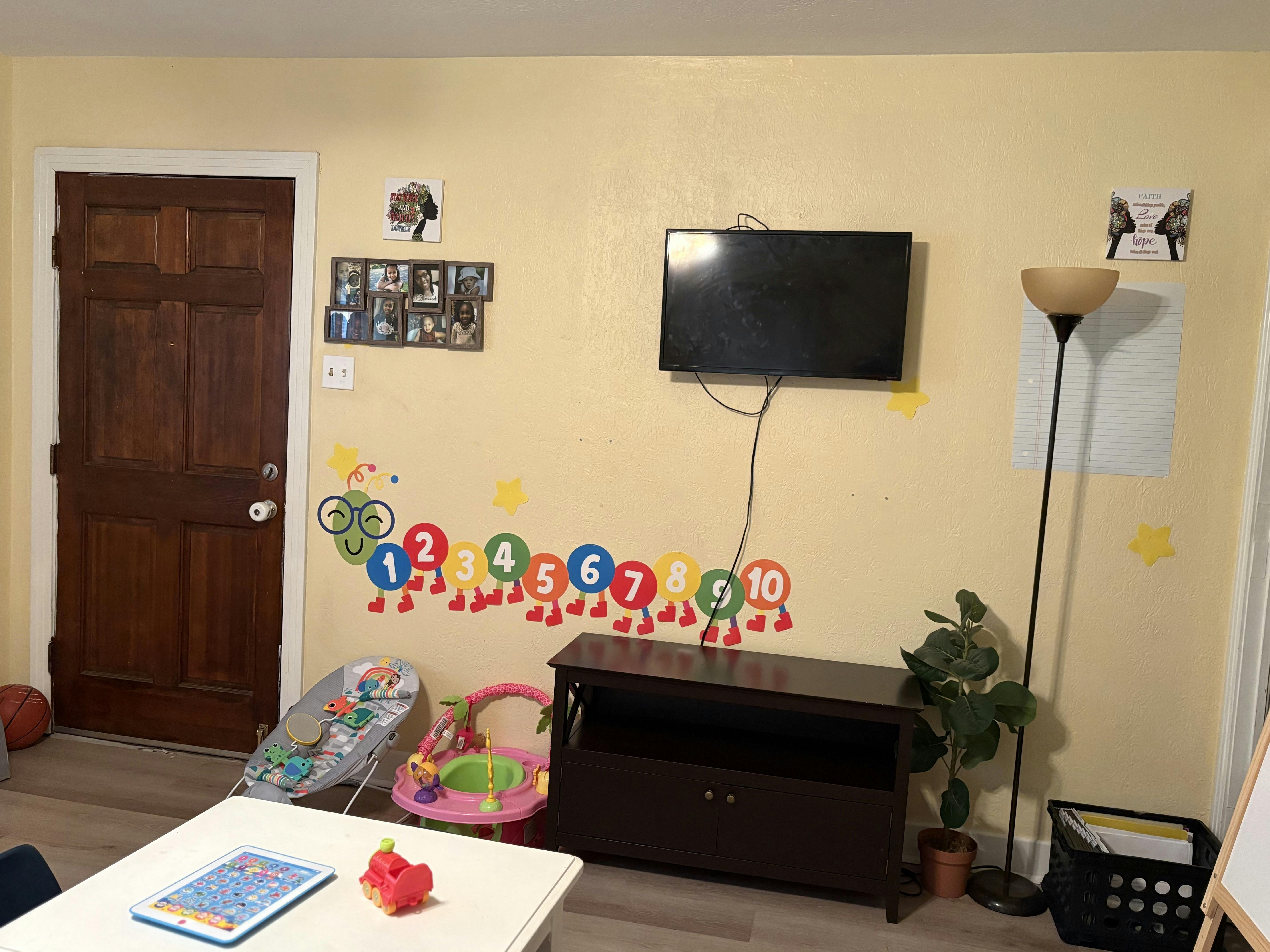 Wall with a mounted television, number decorations, and a closed door