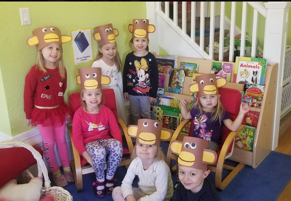 Group of children wearing monkey hats in a classroom