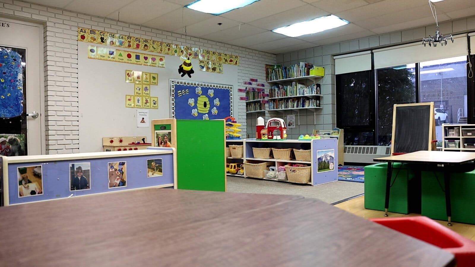 Empty classroom with tables, chairs, and shelves