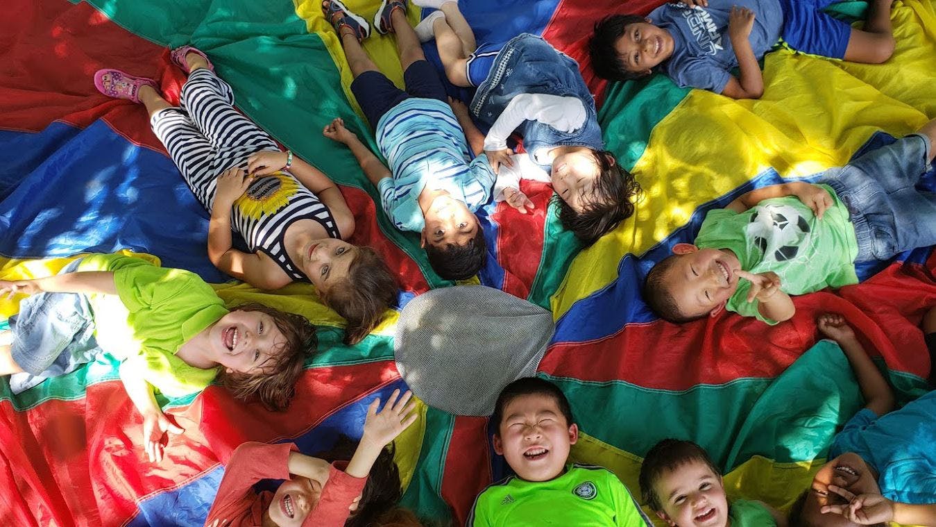 Children lying on a colorful parachute