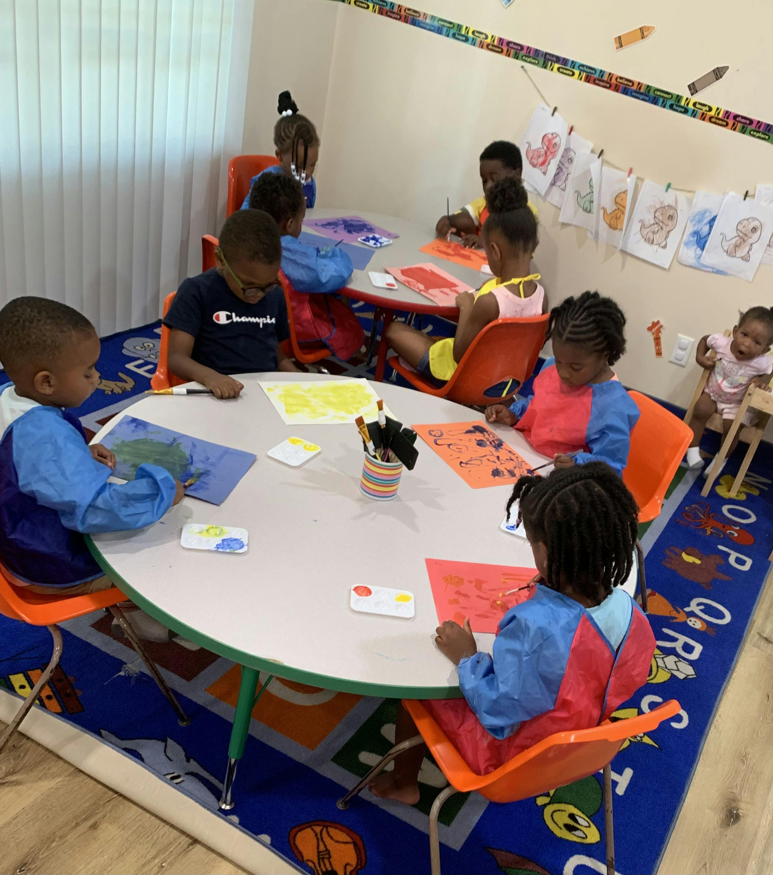 Children sitting at tables and drawing in a classroom