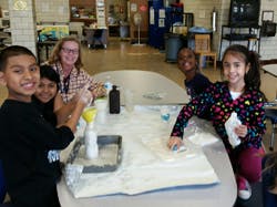 Adult and children around a table with craft supplies