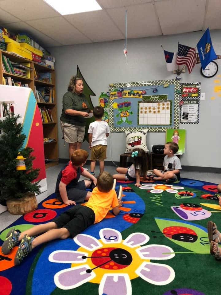 Adult person interacting with children in a classroom
