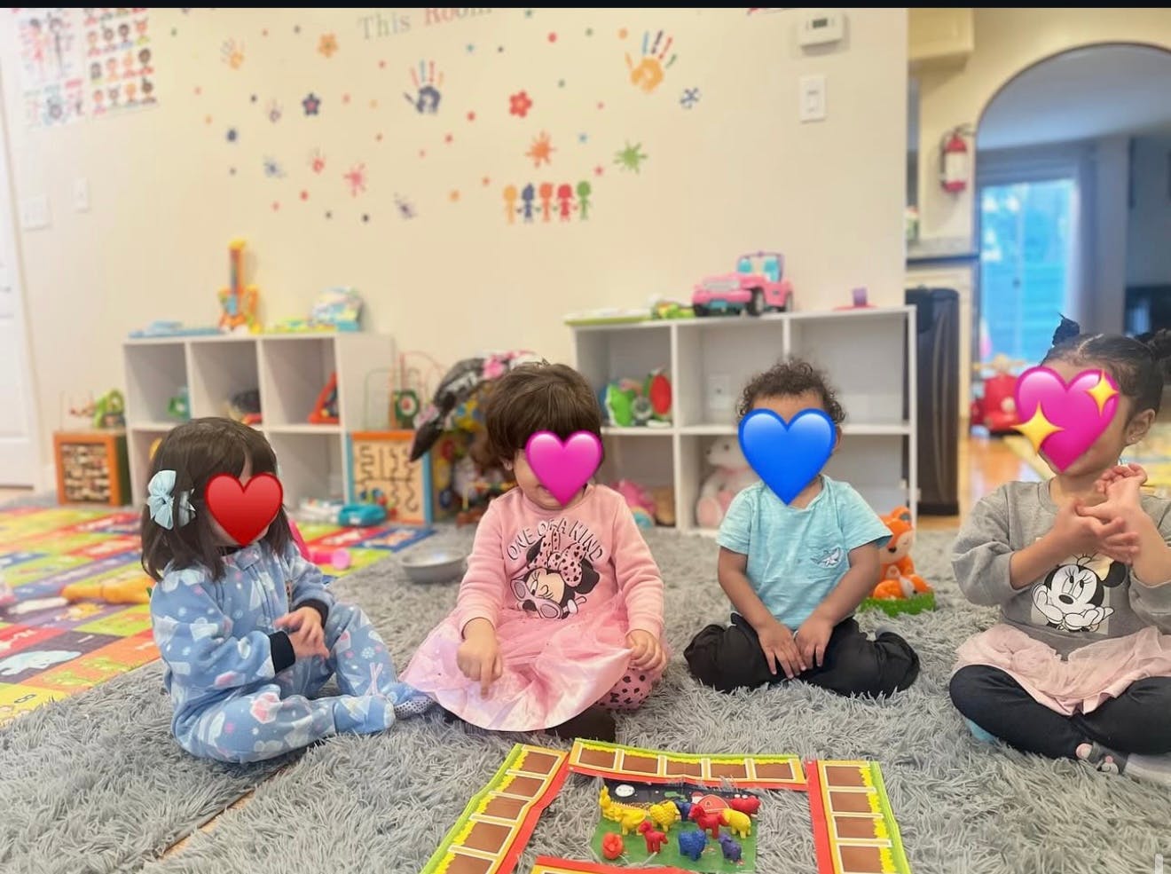 Three children sitting on a rug in a classroom
