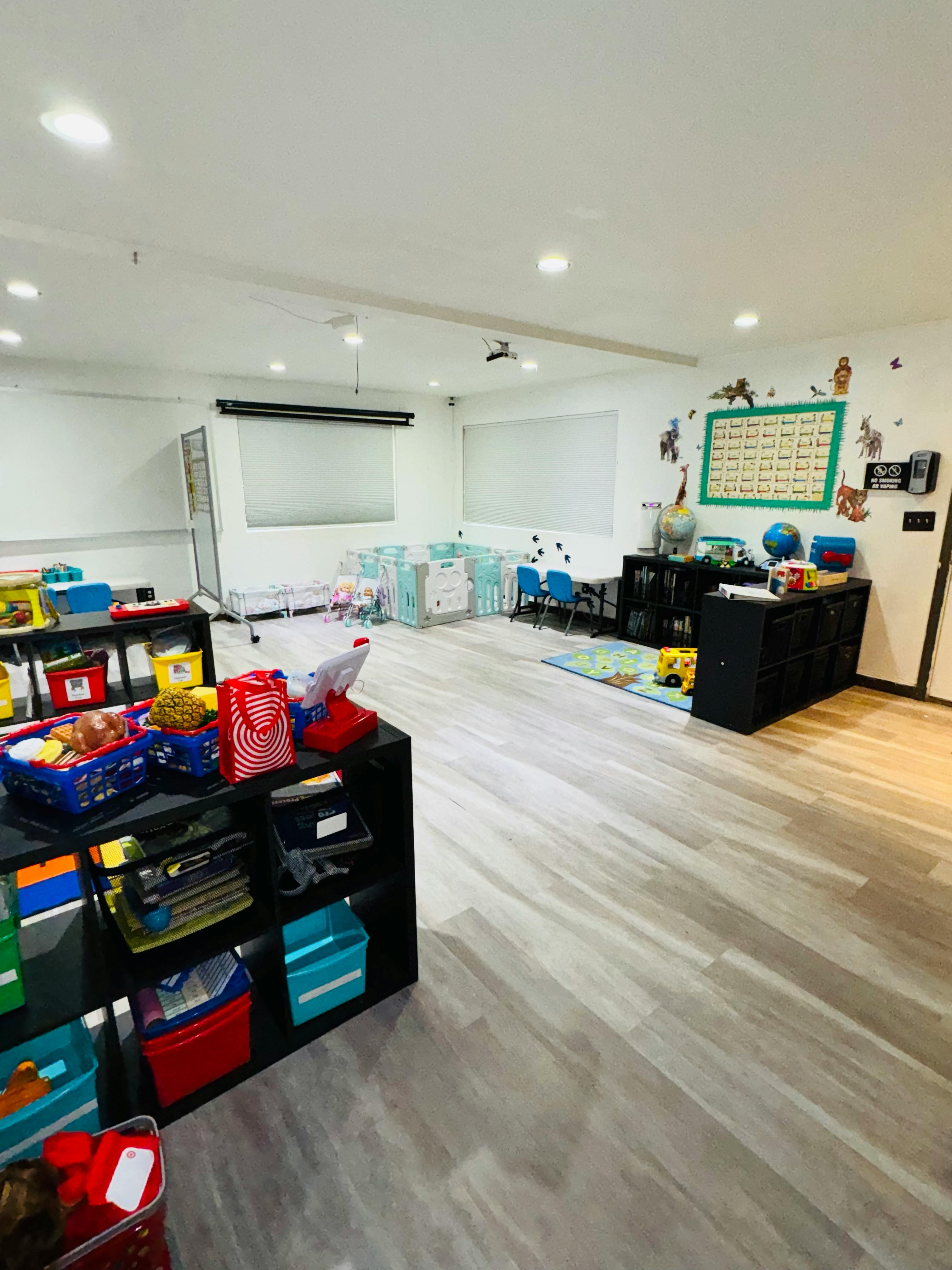 Classroom with shelves of toys and small tables with chairs