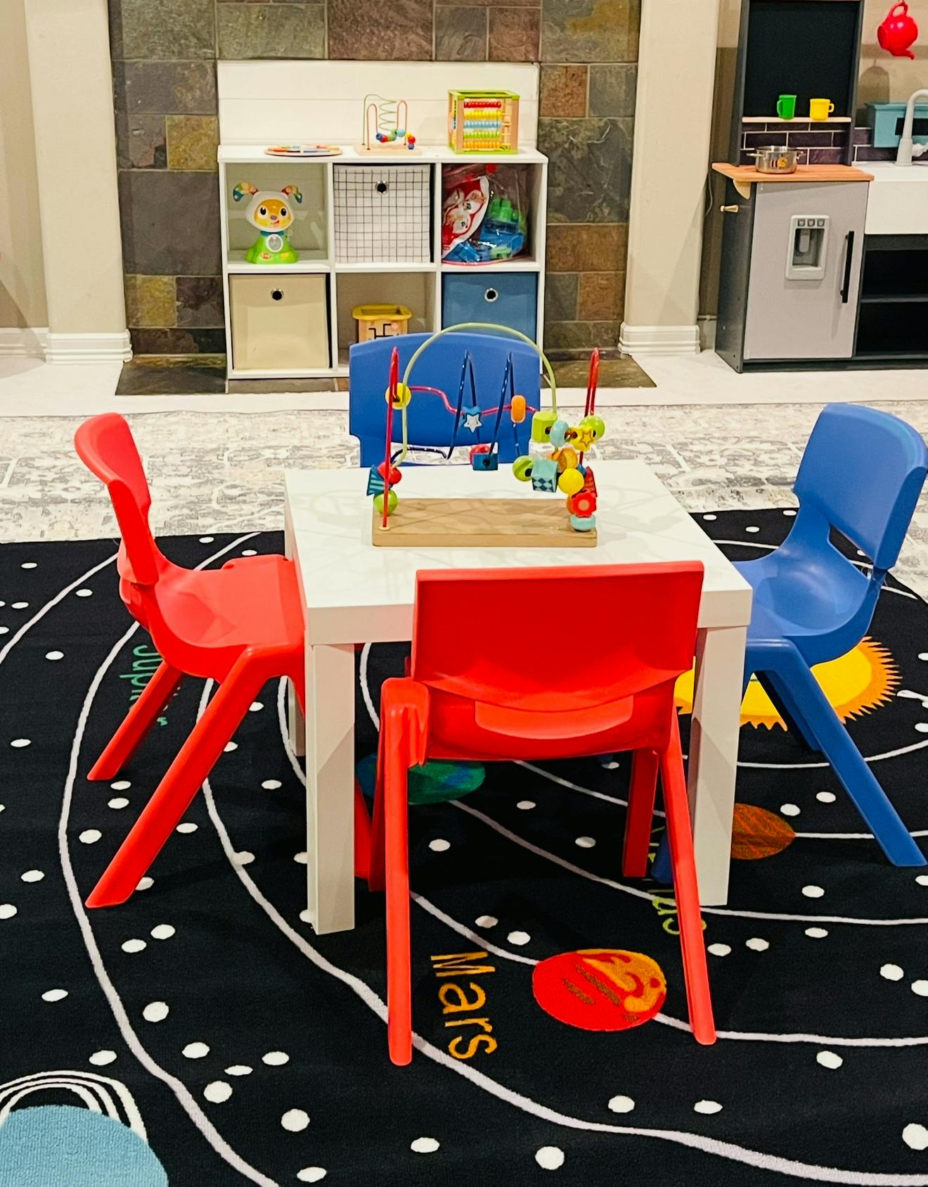 Small white table with red and blue chairs in a play area