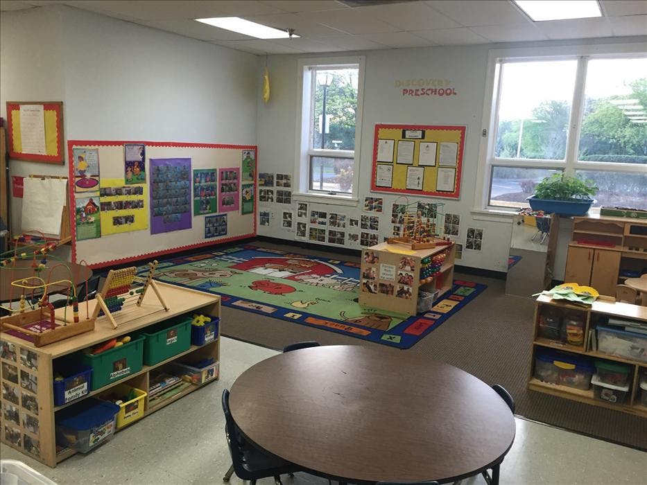 A classroom with a colorful rug, activity centers, and bulletin boards