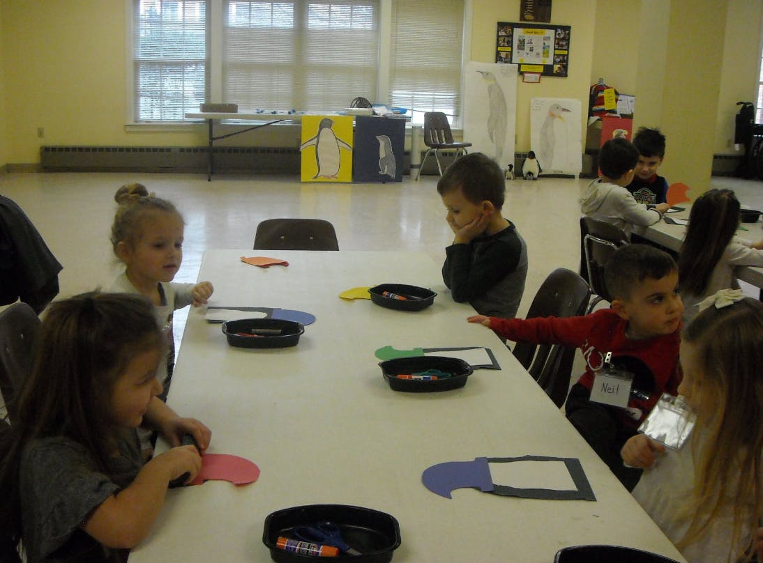 Children sitting at a table with craft supplies