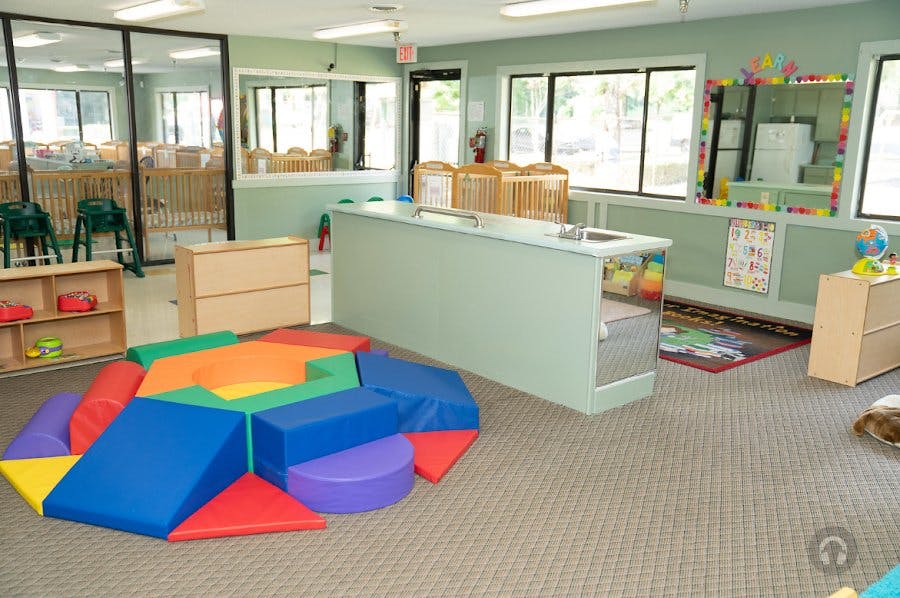 Colorful soft play blocks on a carpeted floor in a classroom