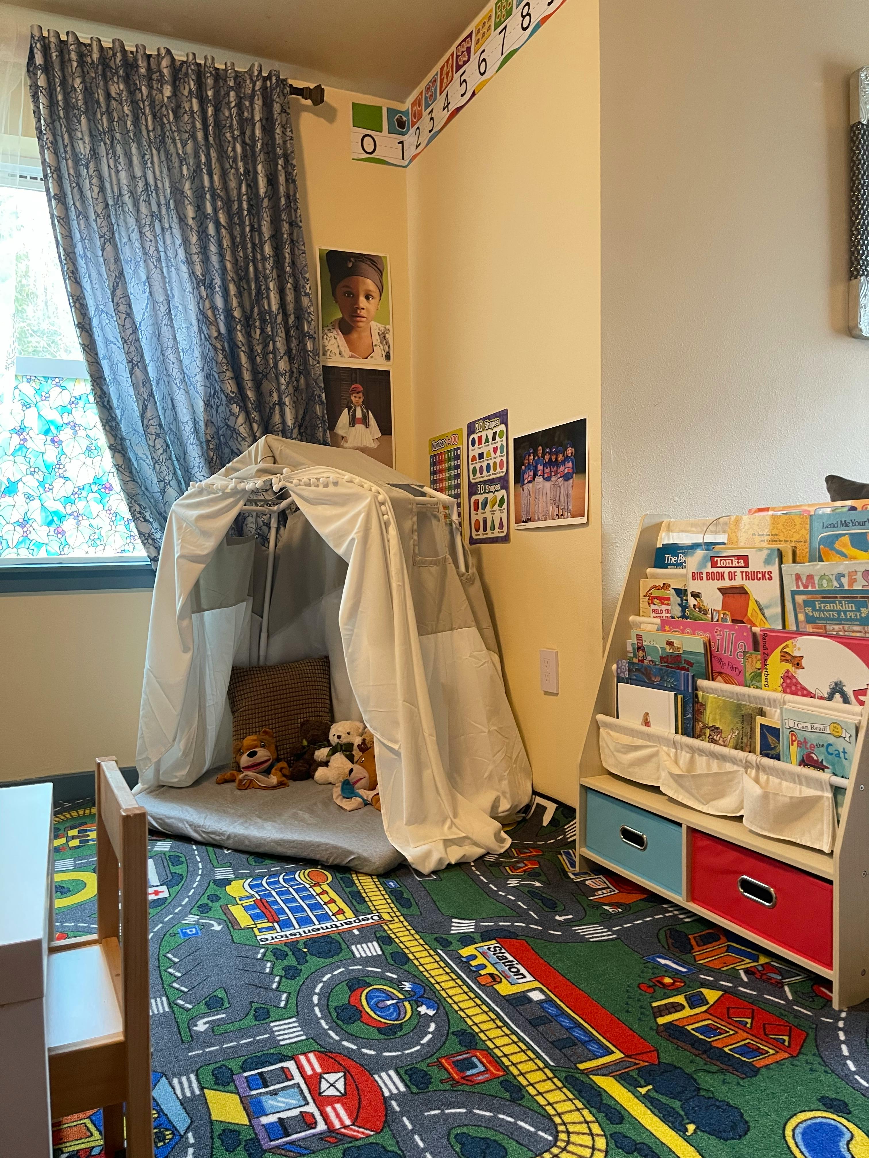 Playroom with a tent, stuffed animals, and a bookshelf with children's books