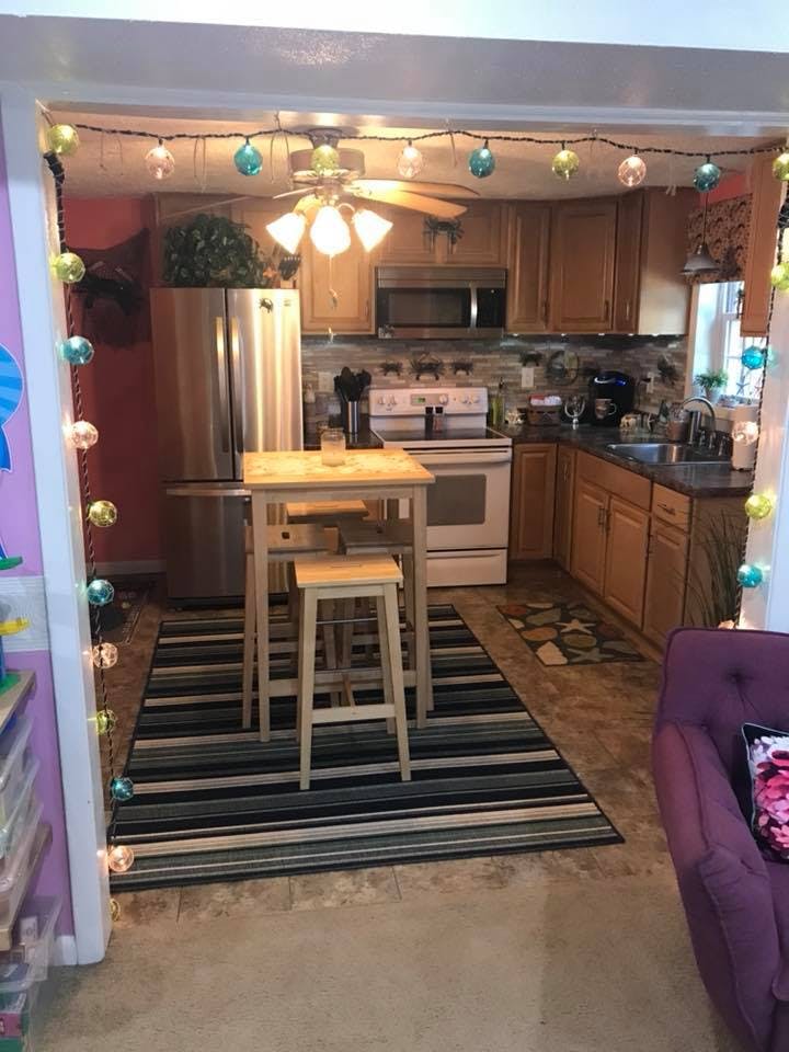 Kitchen with wooden cabinets, stainless steel appliances, and a small dining table