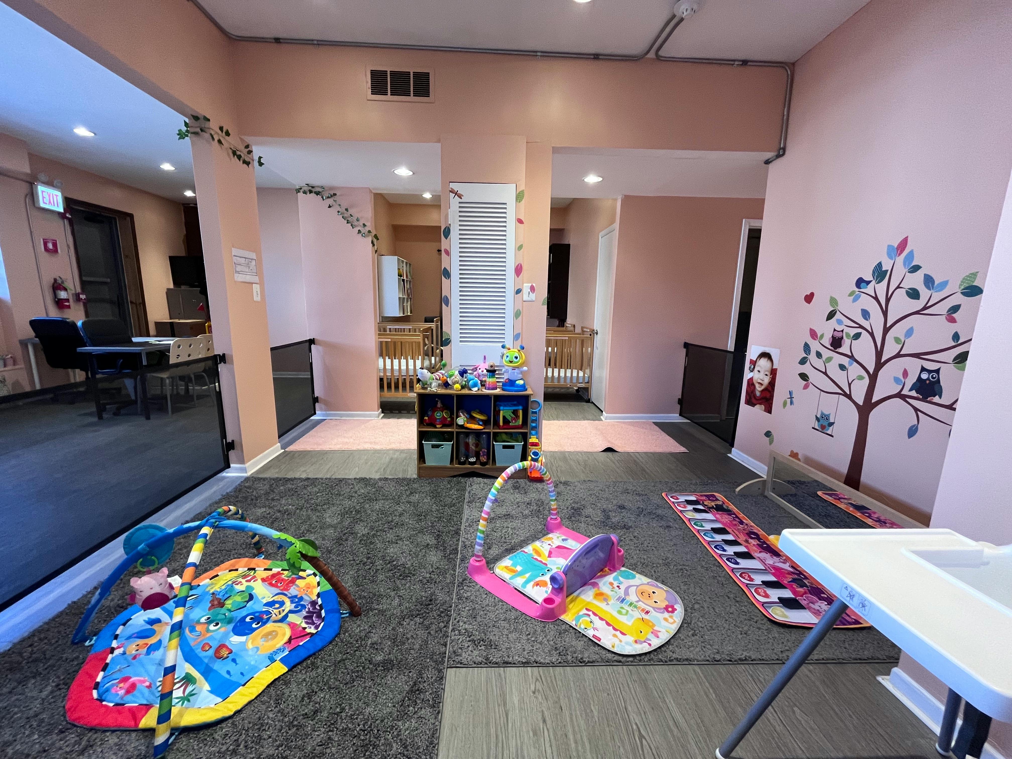 Playroom with baby activity mats and cribs in the background