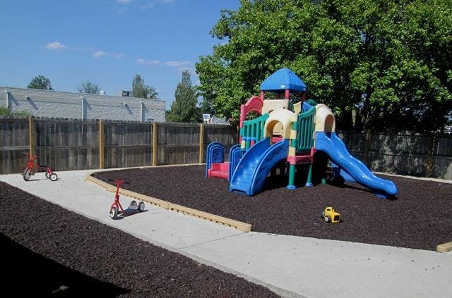 Playground with swings, slides, a small tricycle, and a scooter