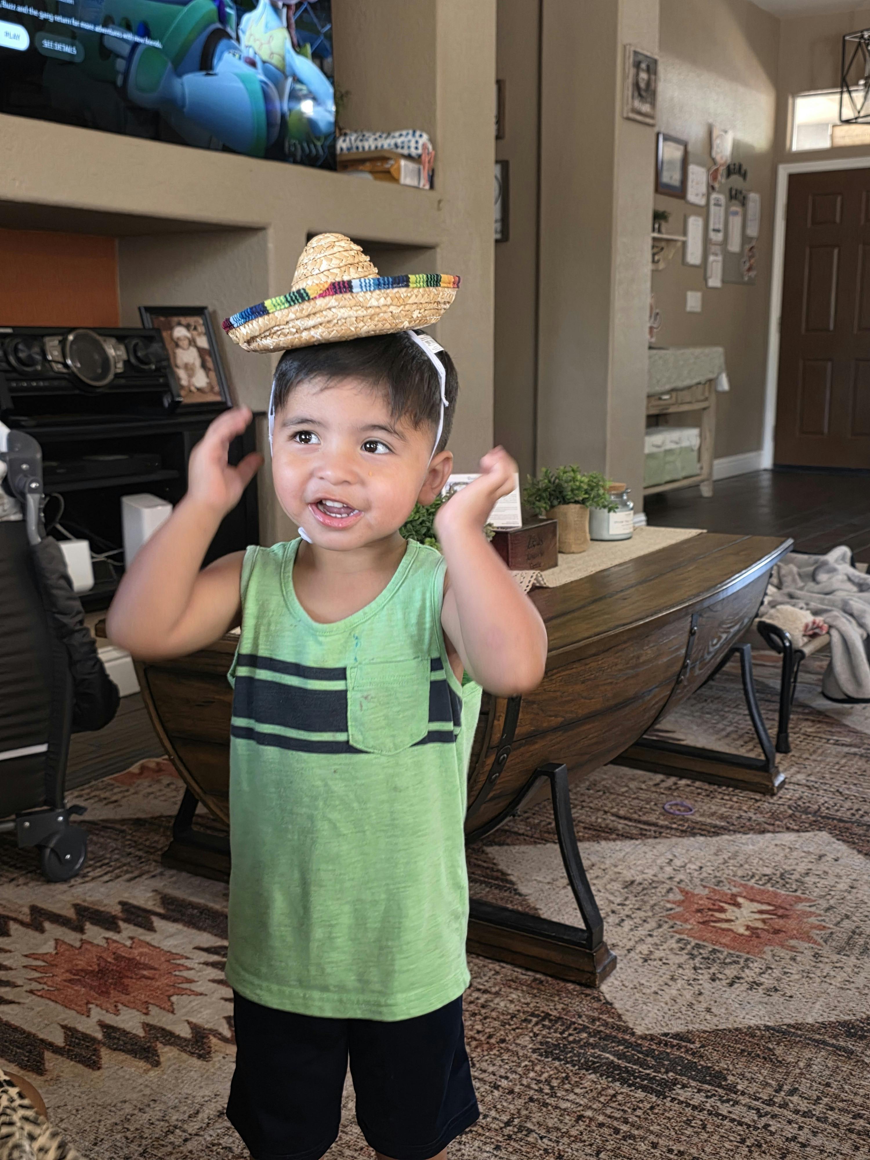 Child wearing a small sombrero hat in a living room