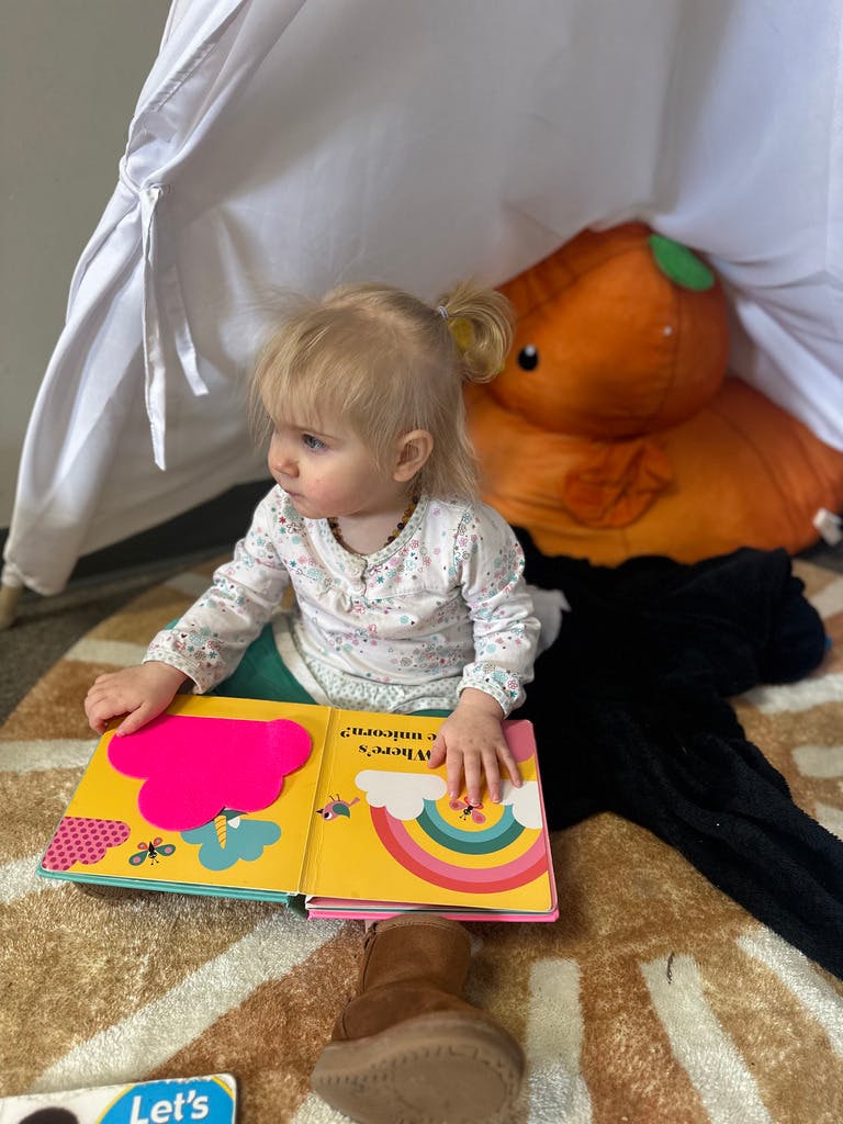 Child sitting on floor with open book