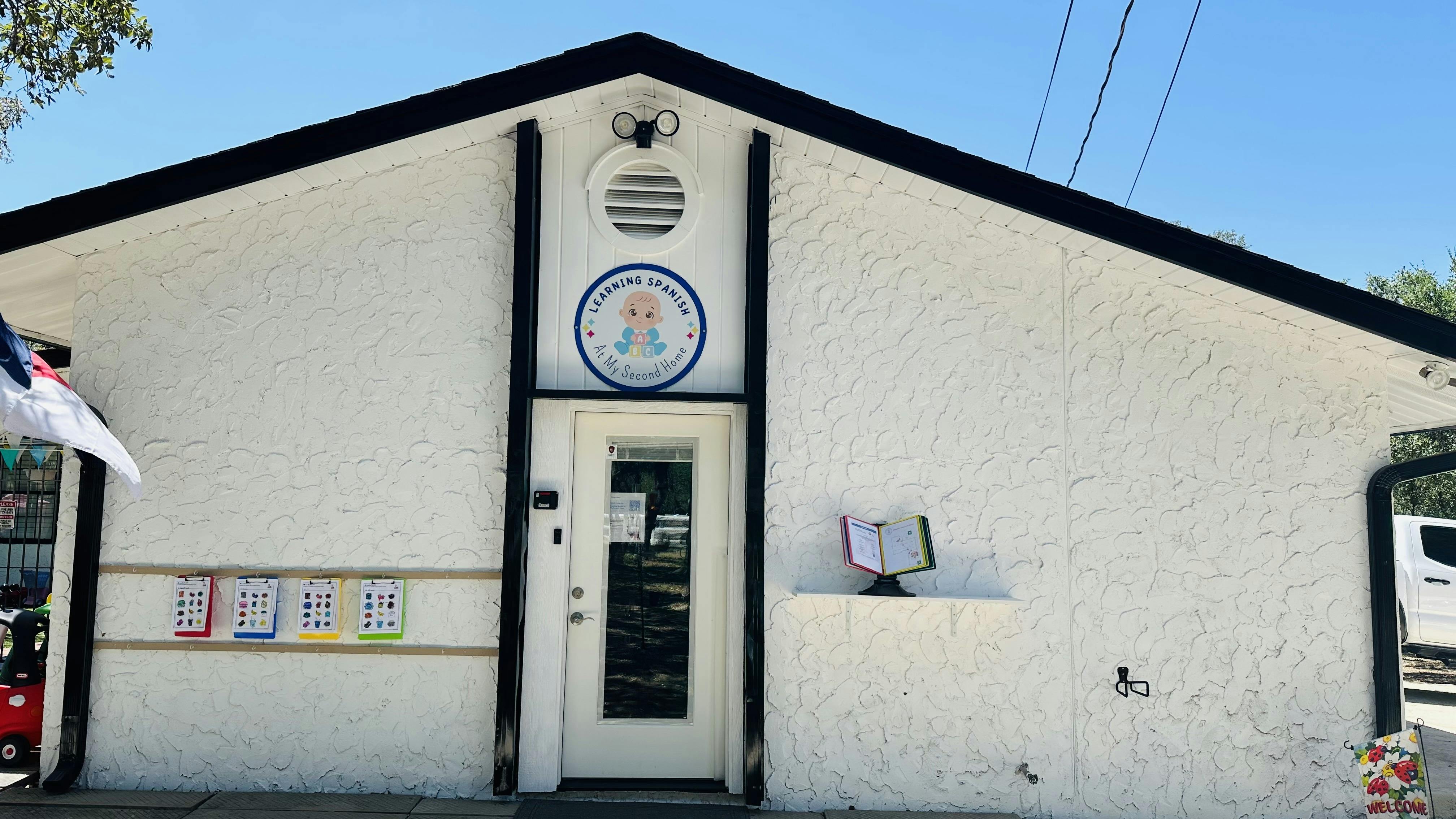 White building with a door and a circular sign above it