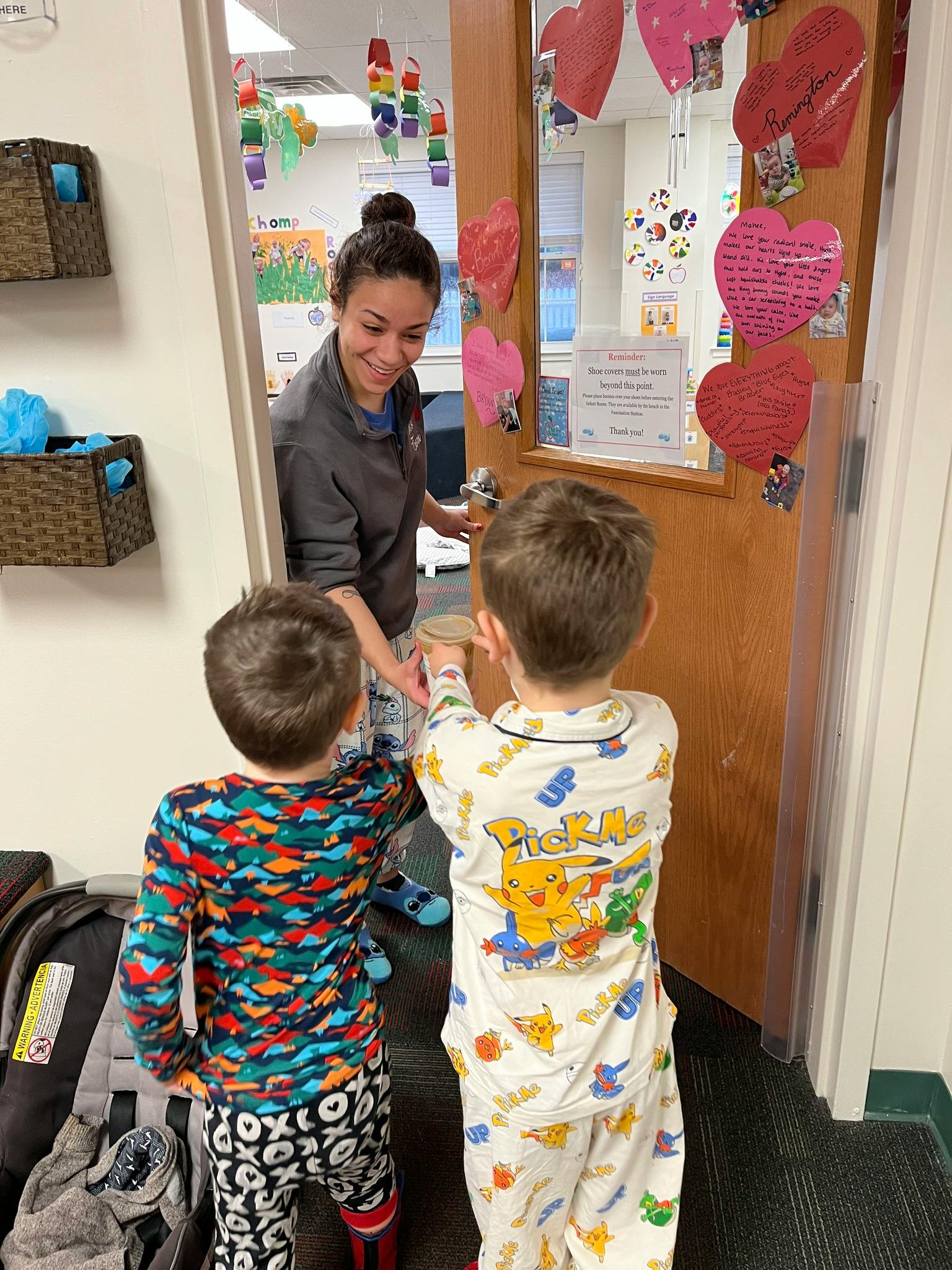 Person handing an object to a child in a doorway