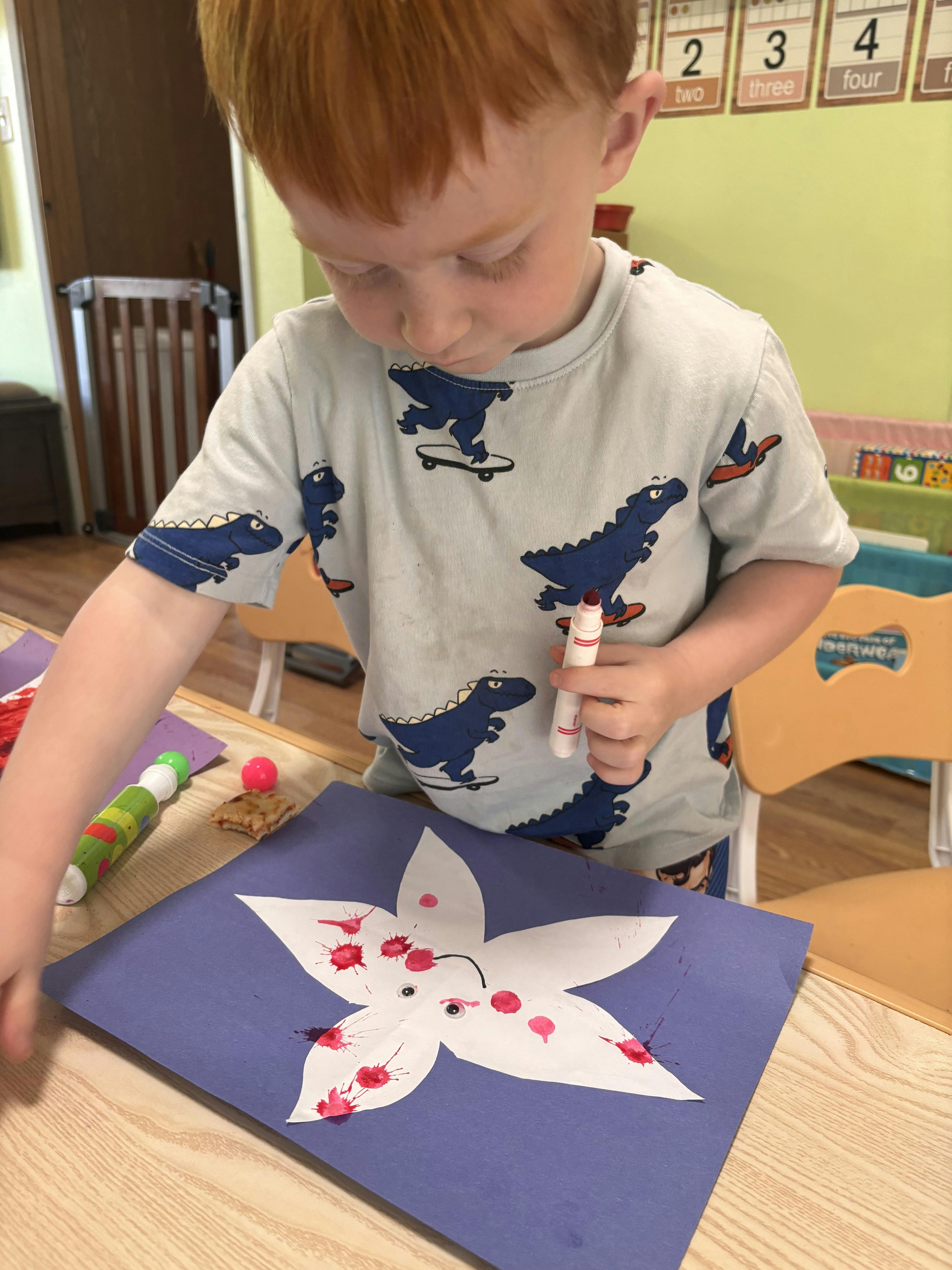 Child crafting a flower shape on construction paper at a table