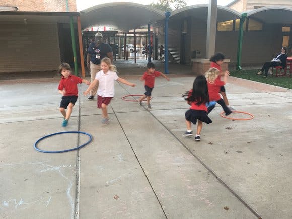 Children running and playing with hoops outdoors
